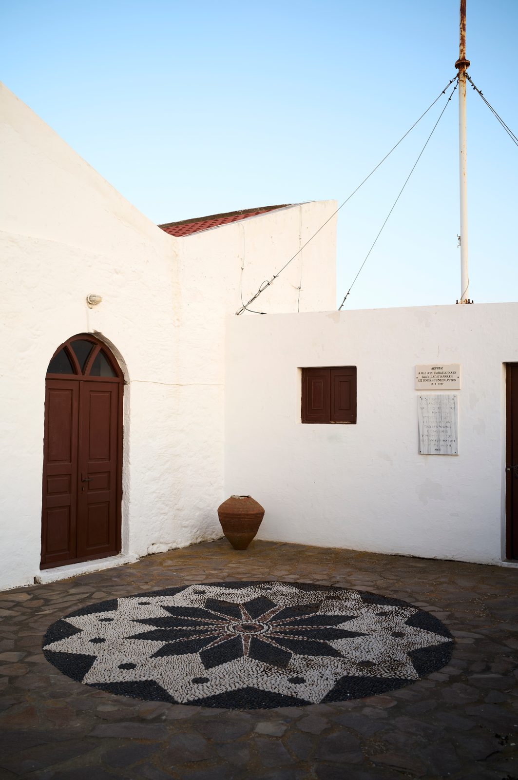 Une église et son parterre en mozaïque de galets à Emborio